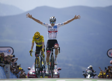 Slovenia's Tadej Pogacar celebrates as he crosses the finish line ahead of Denmark's Jonas Vingegaard.