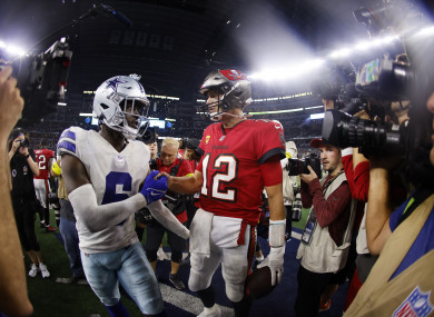 Tampa Bay Buccaneers quarterback Tom Brady with Dallas Cowboys safety Donovan Wilson.